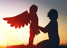 Child with wings comforted by a woman